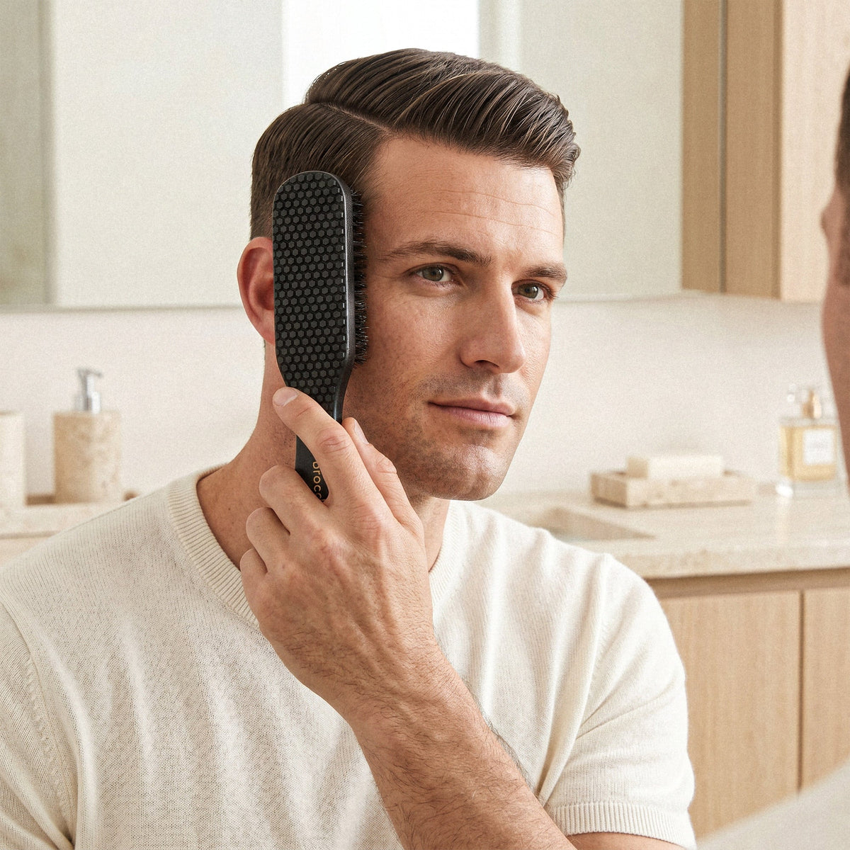 Smoothing the side of the hair with a boar bristle brush