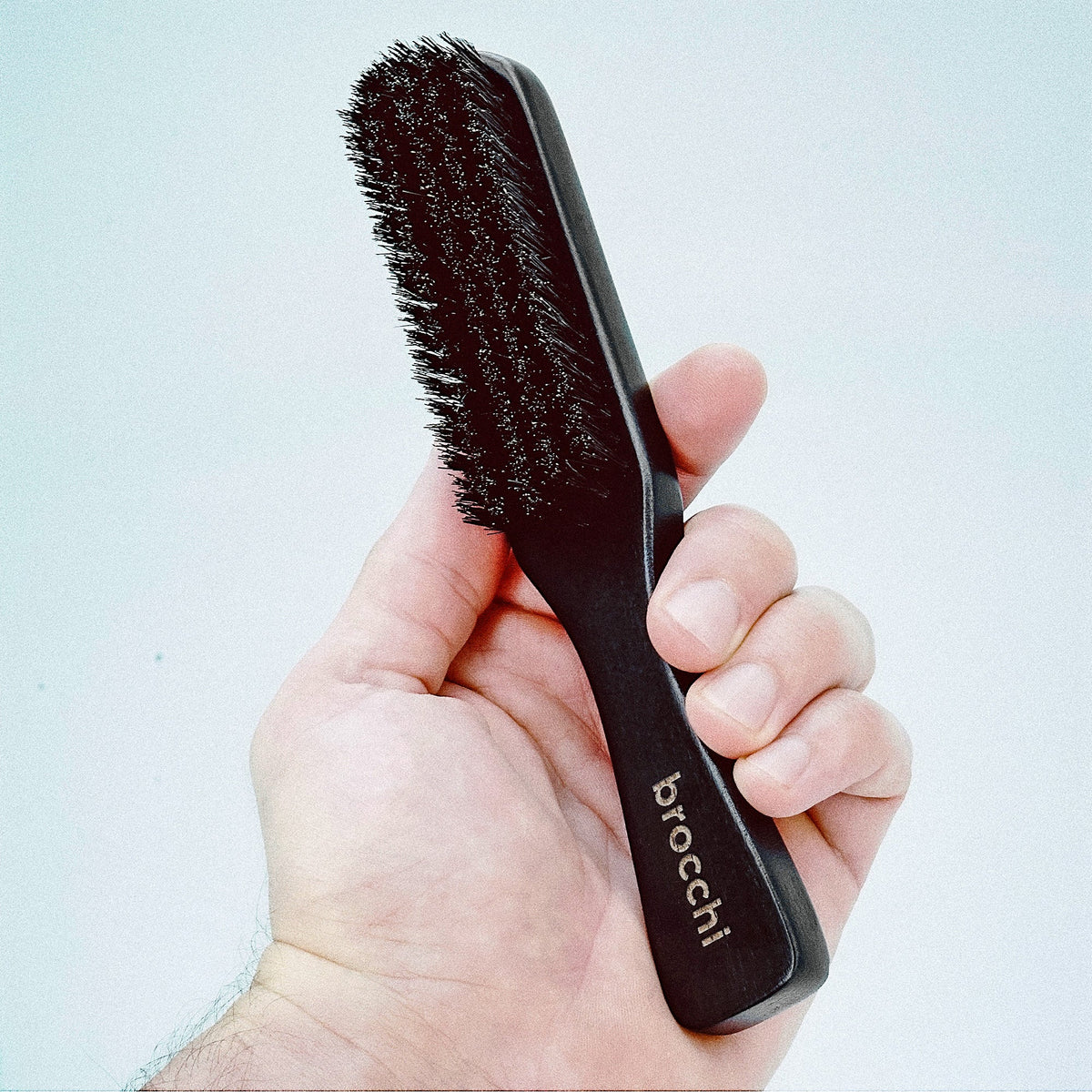 Boar Bristle Polishing Paddle Brush held in hand