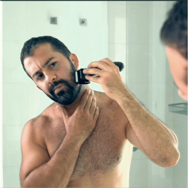 Trimming a beard with the Digital Grooming Trimmer at the bathroom mirror